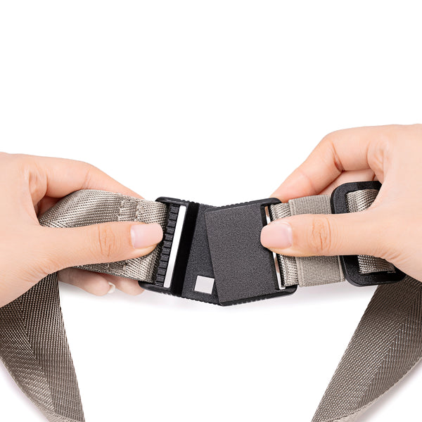 Person adjusting a Champagne Taupe belt with a buckle.