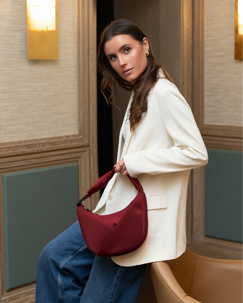 Woman holding a red handbag in an indoor setting