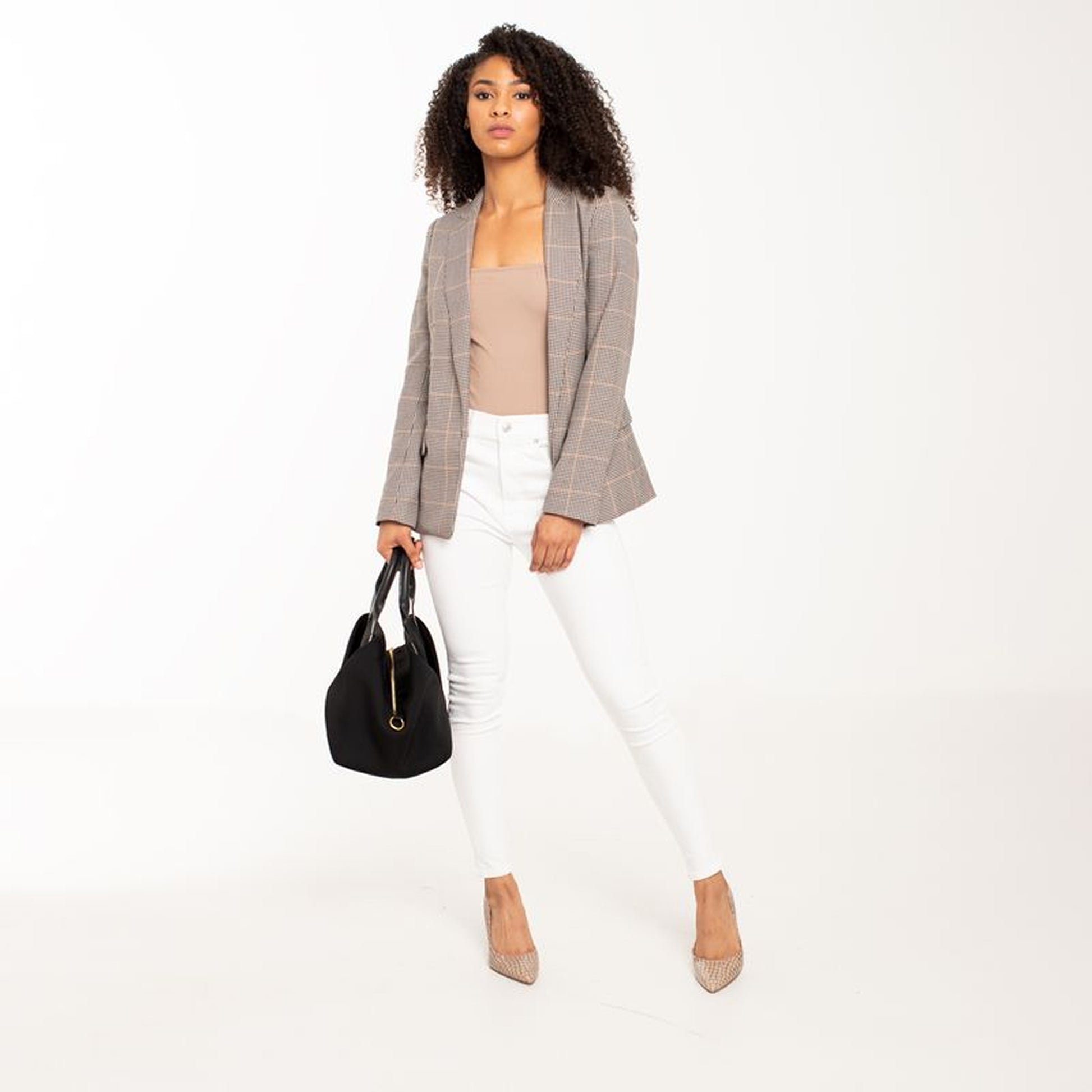 A lady stand with Black + Gold Hardware handbag.