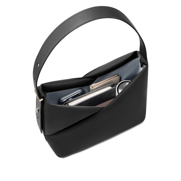Top view of the black Origami Hobo Bag held open, showing the curved handle and interior essentials.
