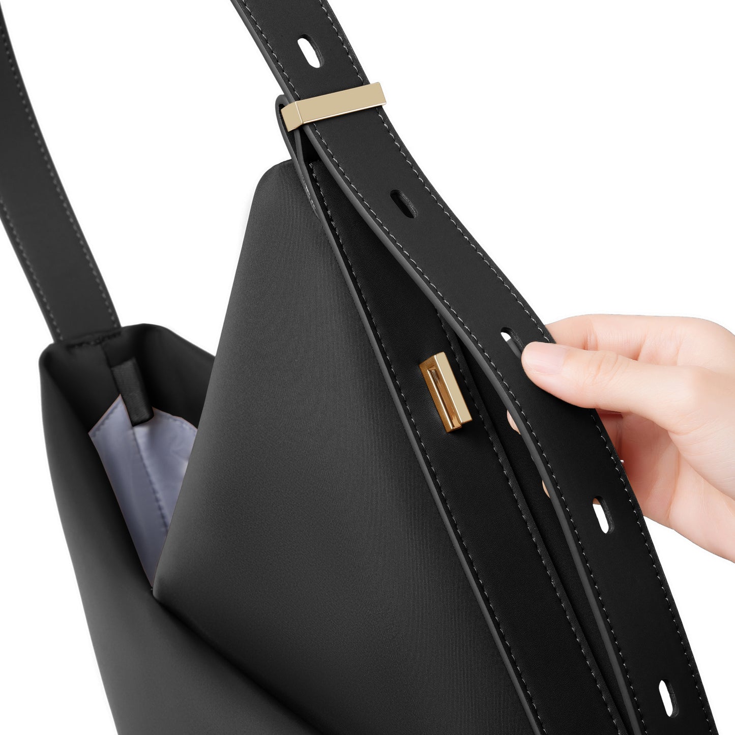 Close-up of the black Origami Hobo Bag's interior structure and side detail as a hand holds it open.
