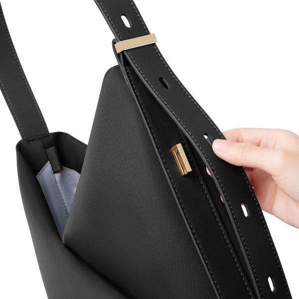 Close-up of the black Origami Hobo Bag's interior structure and side detail as a hand holds it open.

