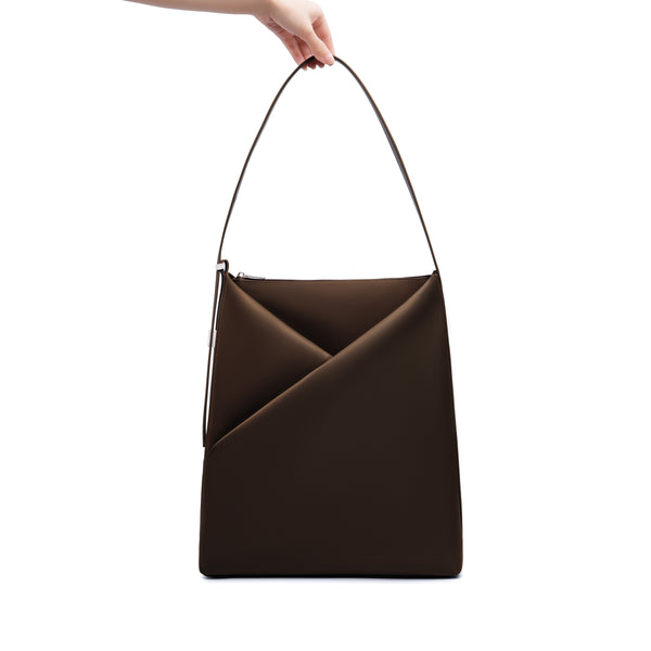 Espresso Origami Hobo Bag held by its handle, emphasizing the structured origami silhouette.
