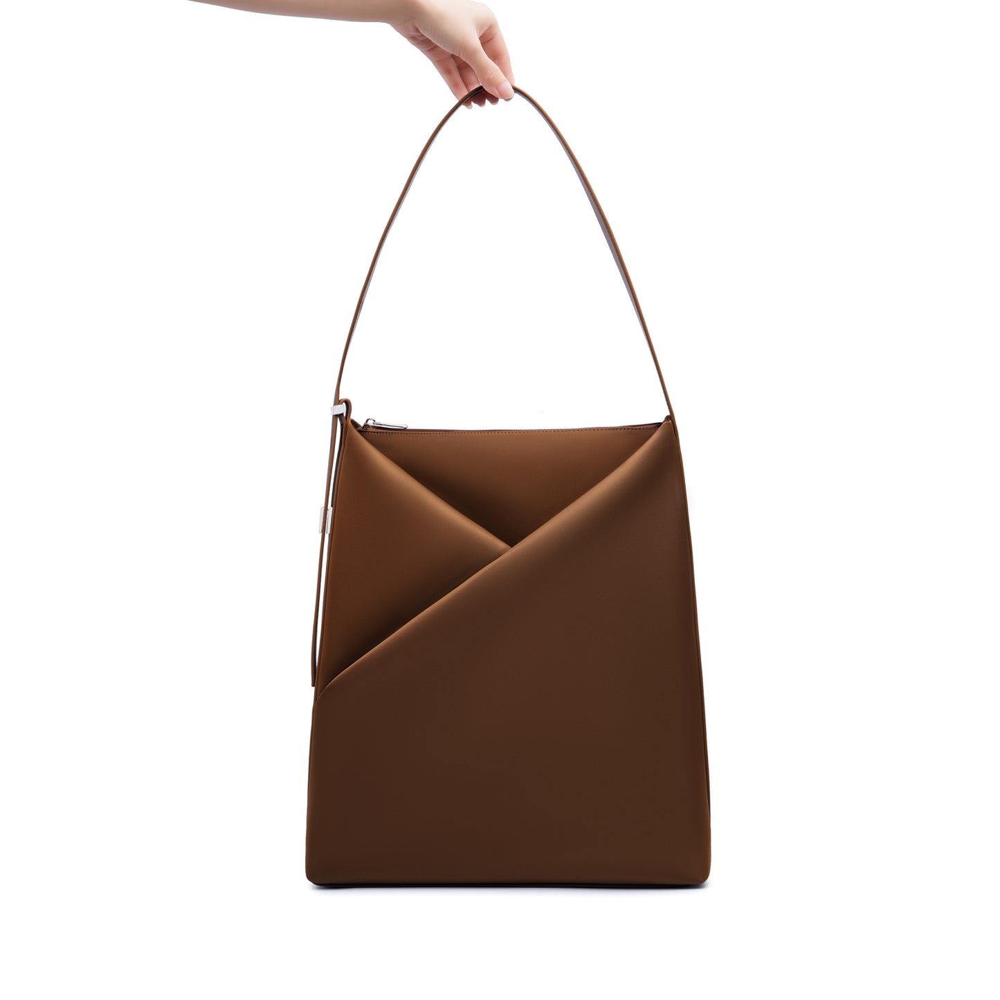Sepia Origami Hobo Bag held by its handle, emphasizing the structured origami silhouette.
