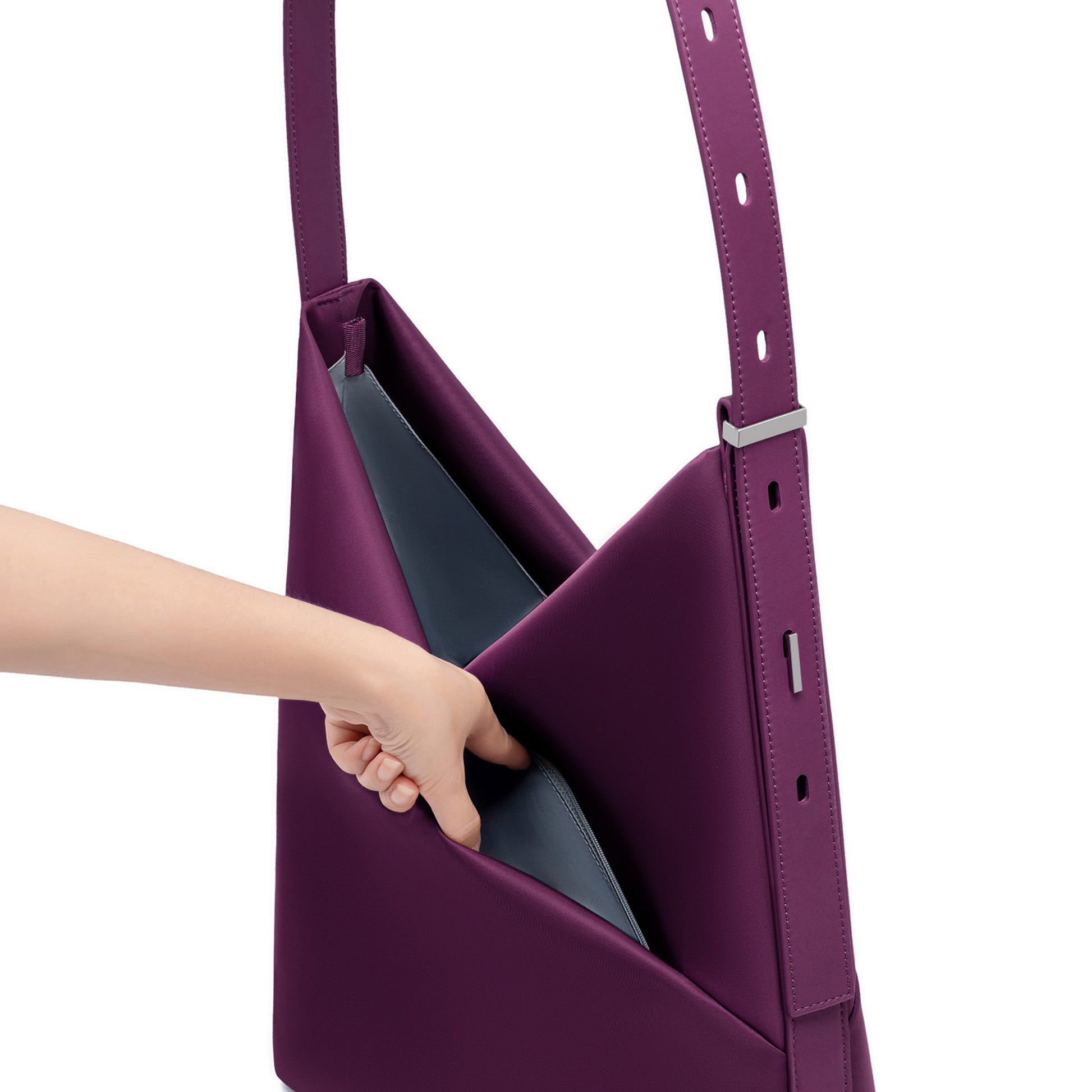 Hand reaching into the open wine Origami Hobo Bag, revealing the soft grey-blue interior lining and adjustable strap.
