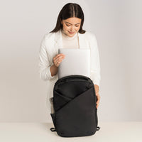 Lux & Nyx Origami Backpack - 16" Laptop Backpack With Trolley Strap - Black - Professional Woman Putting A 16” Laptop Backpack in The 16” Padded Laptop Compartment