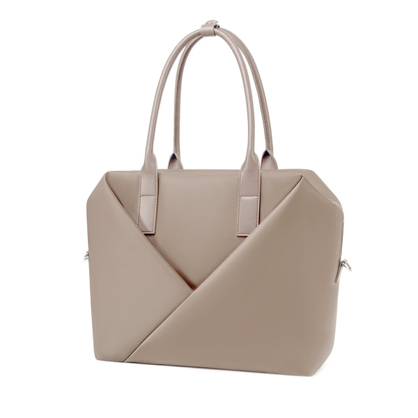 Angled view of a top-handle champagne satchel silhouette with front V-seam detail.