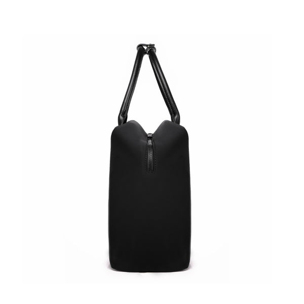 Side profile of a black origami handbag highlighting its slim depth, arched top handles, and clasp closure.
