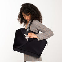 Lux & Nyx Large Origami Tote Ultra Matte - 15" Laptop Tote With Luggage Sleeve - Black - Professional Woman Putting Her Phone Inside The Hidden External Zipped Phone Pocket