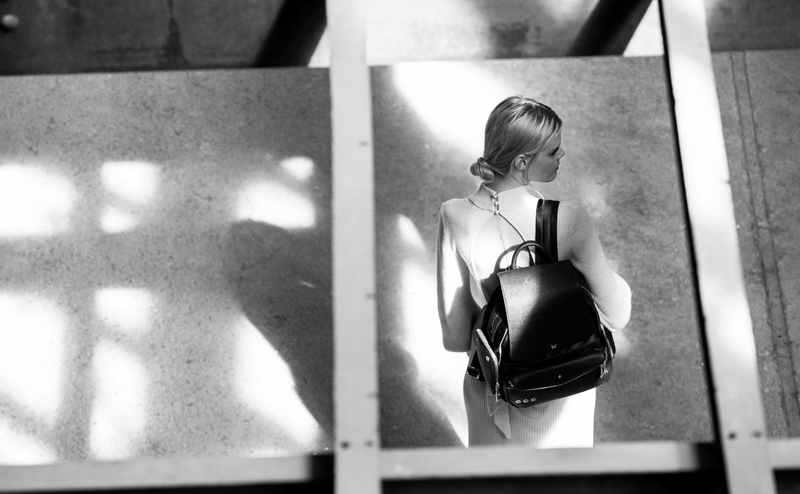 Woman with a black backpack in a reflective surface setting