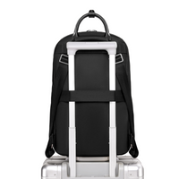 Origami Slim Backpack secured on rolling luggage handle, showing luggage sleeve passthrough