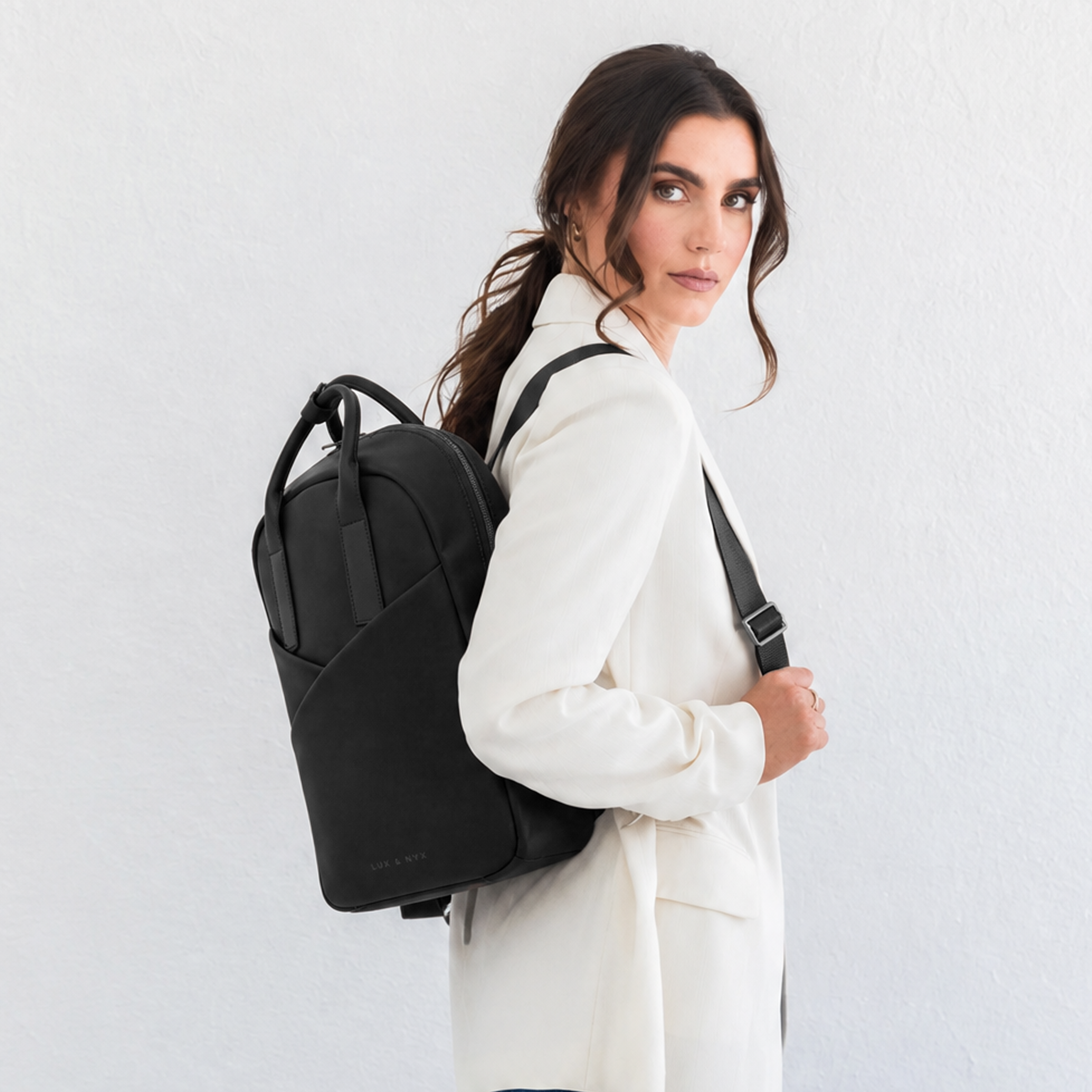 Woman wearing black Origami Slim Backpack over one shoulder