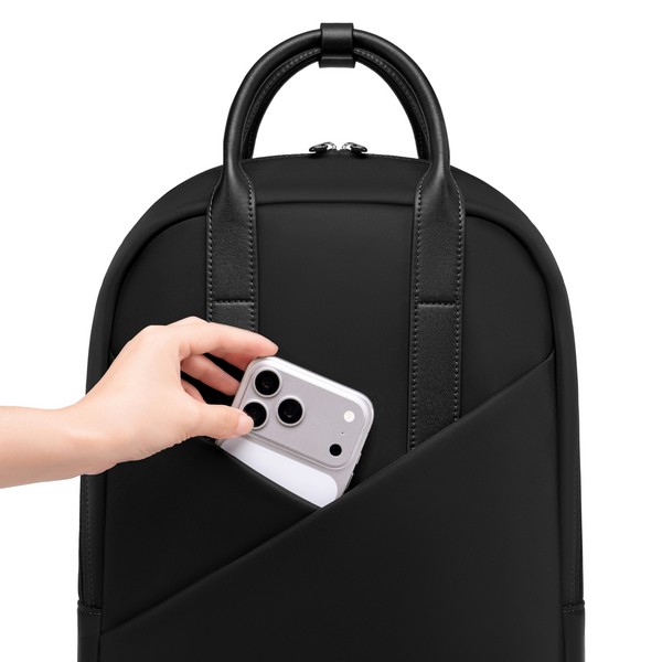 Hand sliding phone into Origami Slim Black  Backpack quick-access front pocket