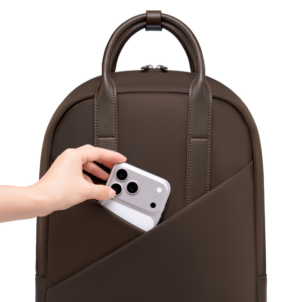 Hand sliding phone into Origami Slim Espresso Backpack quick-access front pocket