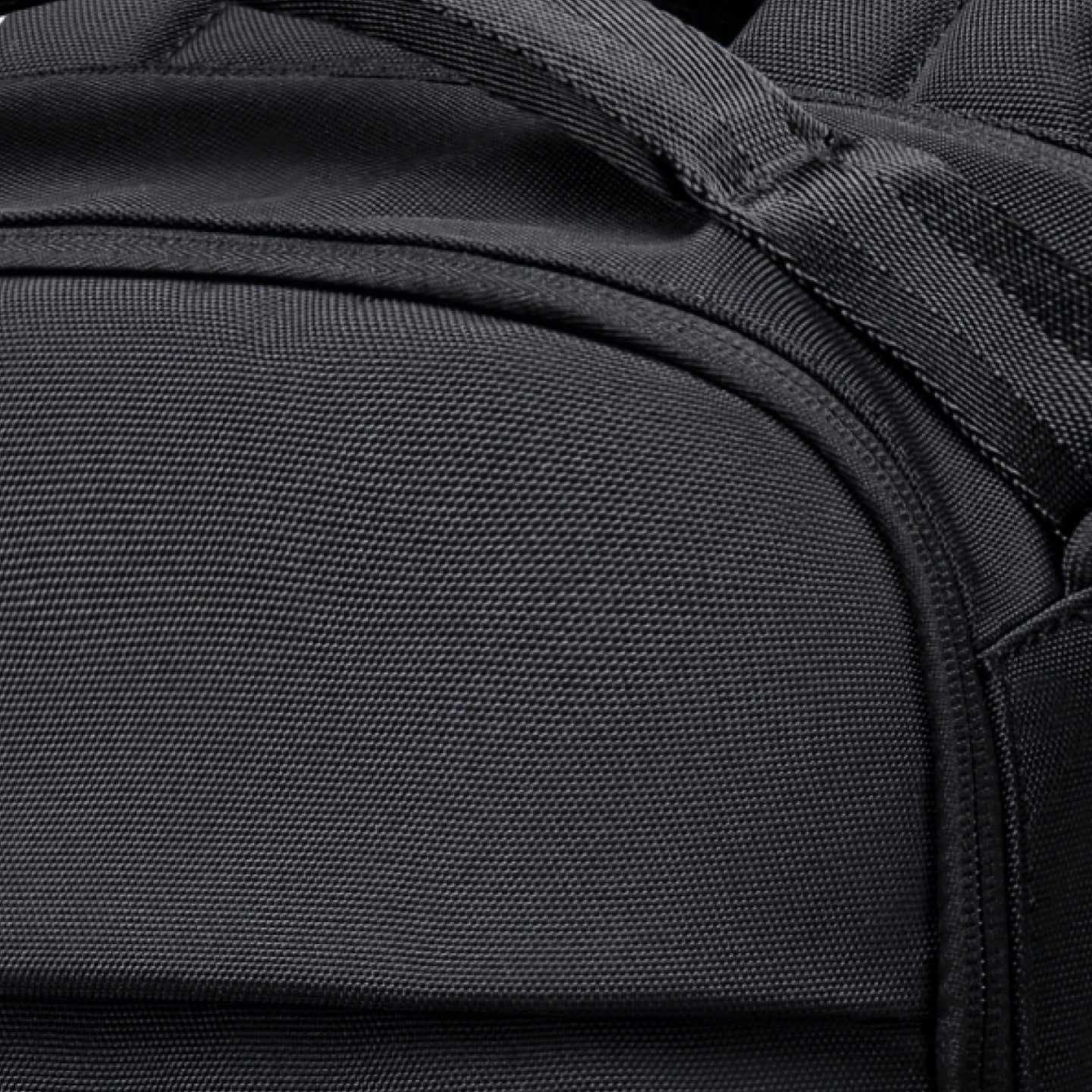 Close-up of a black backpack with textured fabric and stitching details.