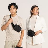 Lux & Nyx Origami Belt Bag and Sling Bag - Black - Male Model Wearing The Belt Bag In Sling Bag Mode, and Female Model Wearing The Belt Bag In Belt Bag Mode