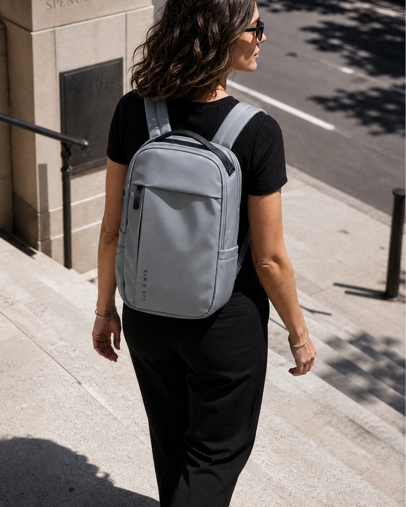Person wearing a gray backpack on a city street