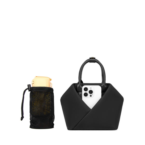 black-with-silver-hardware origami-style leather handbag with structured top handles holding a white smartphone, displayed beside a small black mesh drawstring pouch.