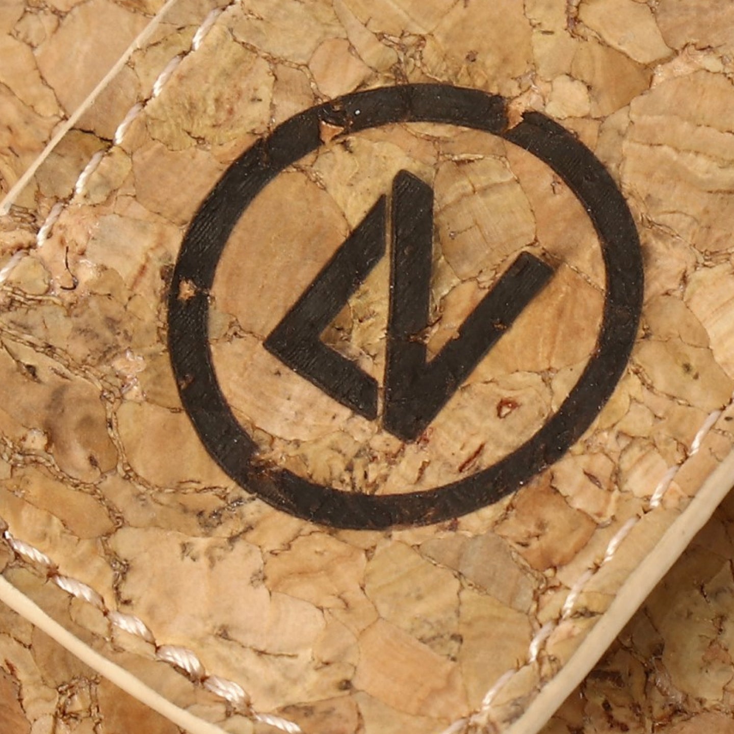 Close-up of a woven basket with a black logo on a textured beige background