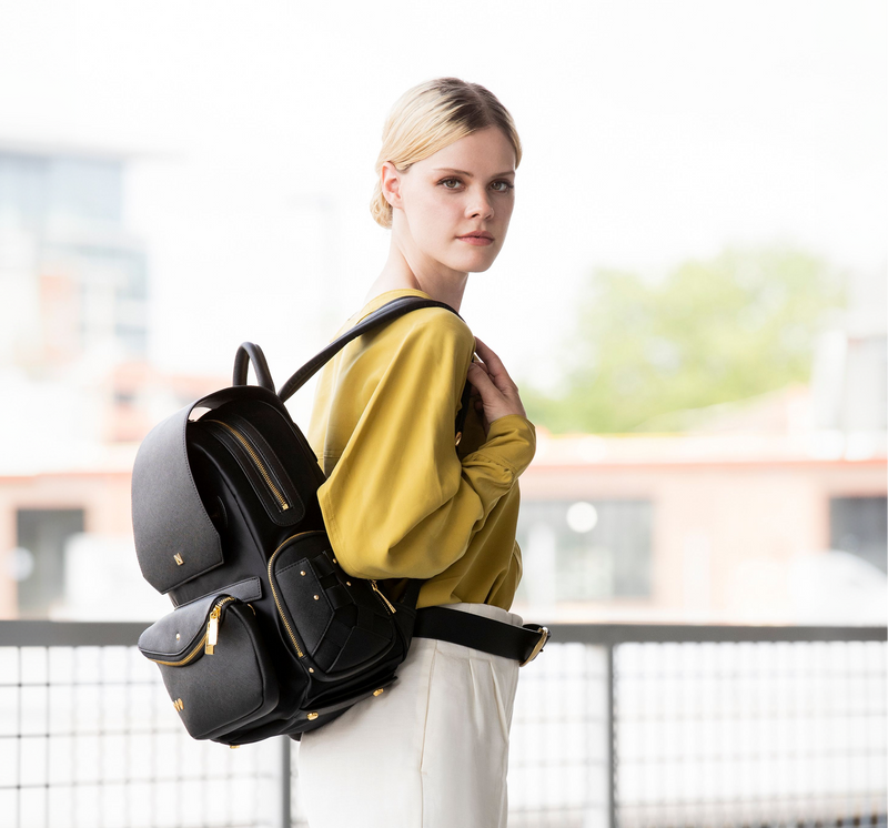 Woman wearing a black backpack outdoors with blurred background